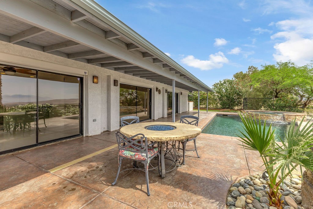 67525 Monterey Road Desert Hot Springs, CA 92240 - Photo 56 of 75 a view of a patio with a table chairs and a backyard