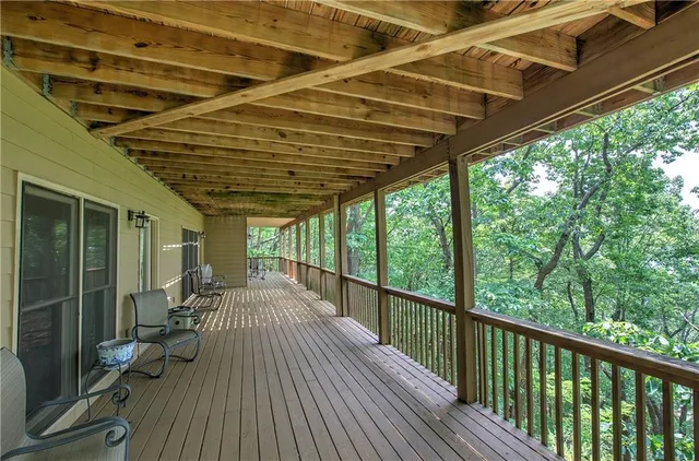 a view of a swimming pool with a bench and trees in the background