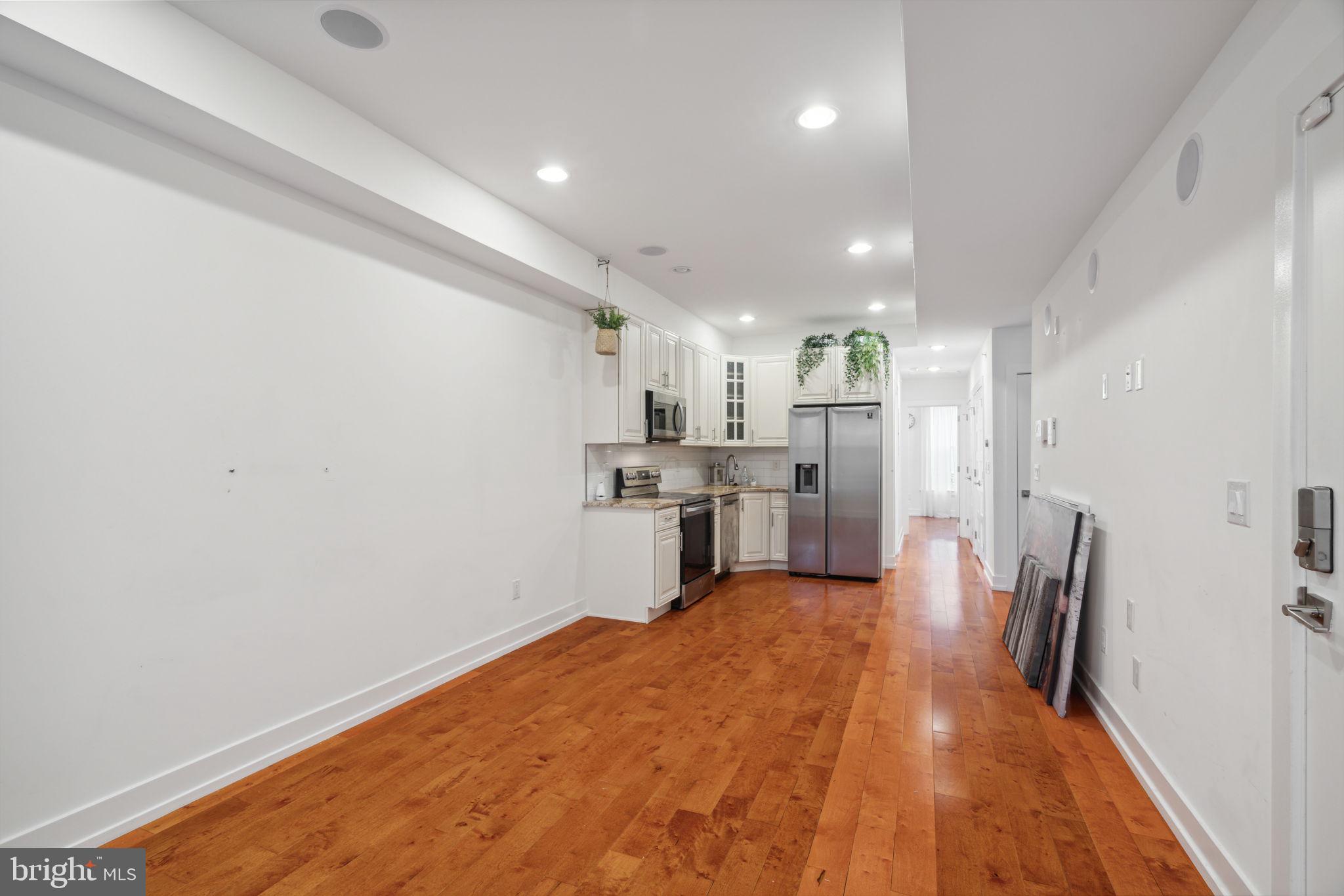 a open kitchen with white cabinets and stainless steel appliances