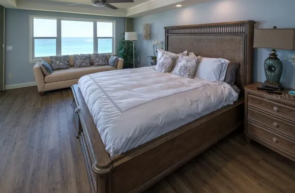 a spacious bedroom with a bed and a table chair