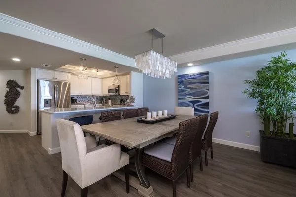 a living room with kitchen island granite countertop furniture and a chandelier