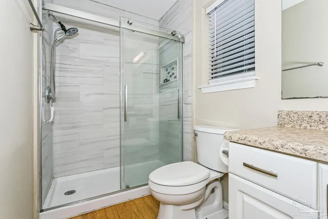 a bathroom with a granite countertop toilet a sink and shower