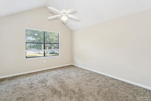 an empty room with windows and fan