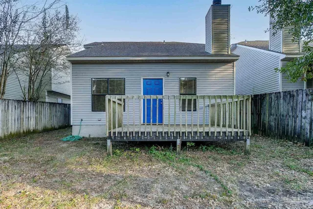 a view of a house with a backyard and wooden fence