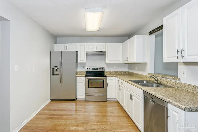 a kitchen with granite countertop a sink stove and refrigerator