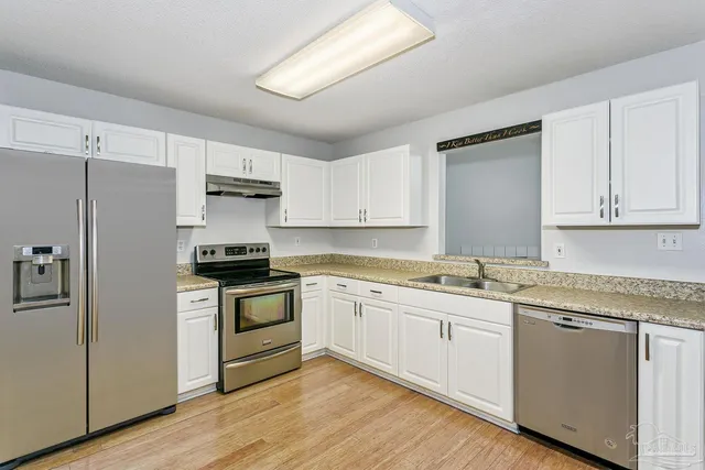 a kitchen with granite countertop white cabinets and white appliances