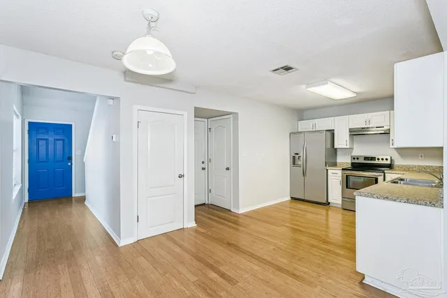 a view of a kitchen with a refrigerator a stove top oven
