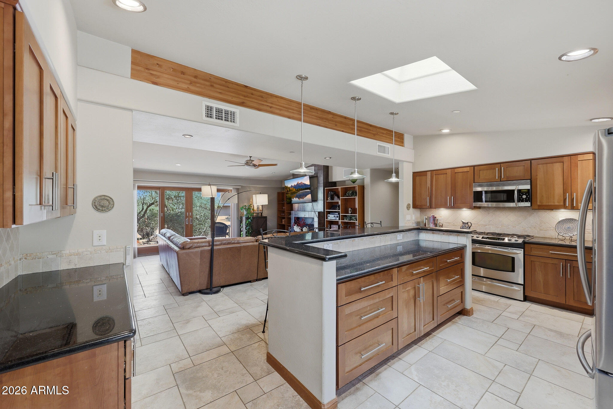 6019 East Blue Ridge Drive Cave Creek, AZ 85331 - Photo 20 of 49 a kitchen with stainless steel appliances granite countertop a stove top oven a sink dishwasher a dining table and chairs with wooden floor