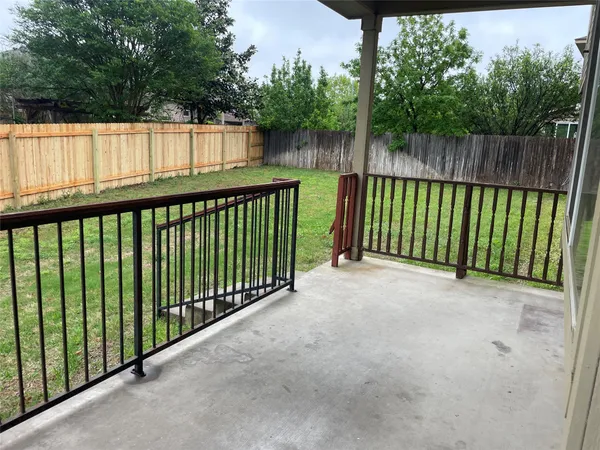a view of a yard with wooden fence
