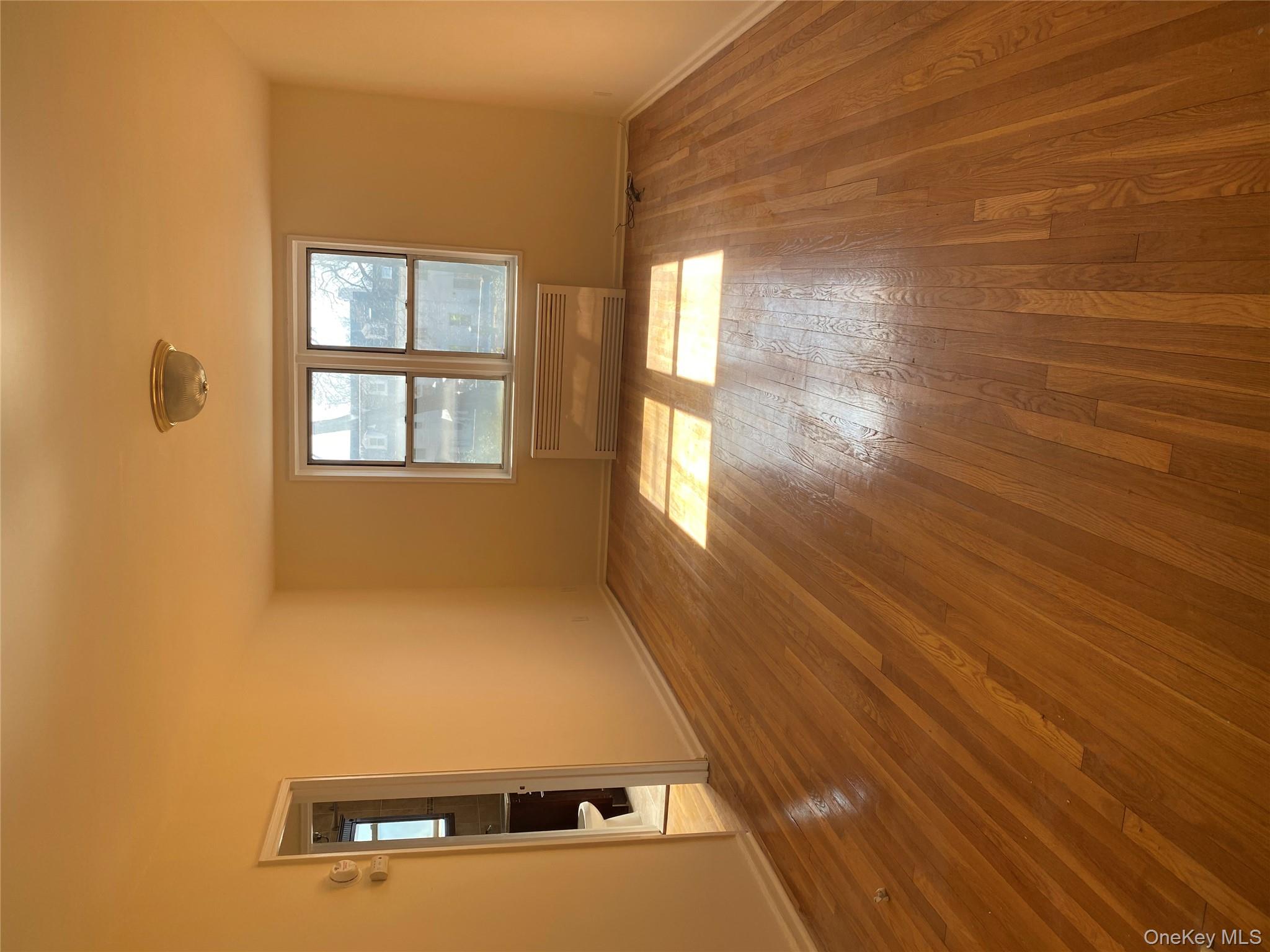 50 South Middle Neck Road, Unit 1B Great Neck, NY 11021 - Photo 3 of 11 wooden floor in an empty room with a window