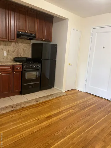 a kitchen with stainless steel appliances granite countertop a refrigerator stove and a sink with wooden cabinets