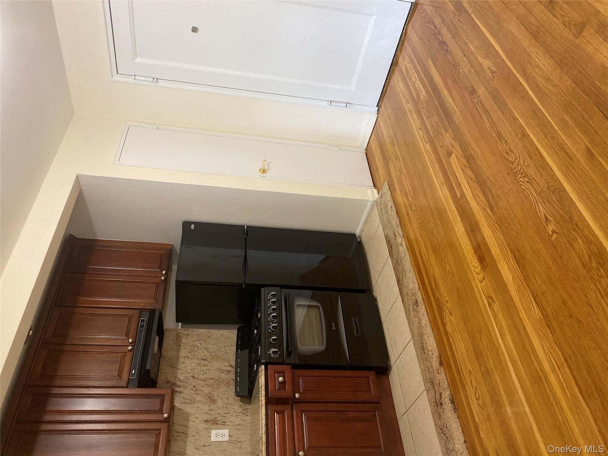 50 South Middle Neck Road, Unit 1B Great Neck, NY 11021 - Photo 5 of 11 a kitchen with stainless steel appliances granite countertop a refrigerator stove and a sink with wooden cabinets