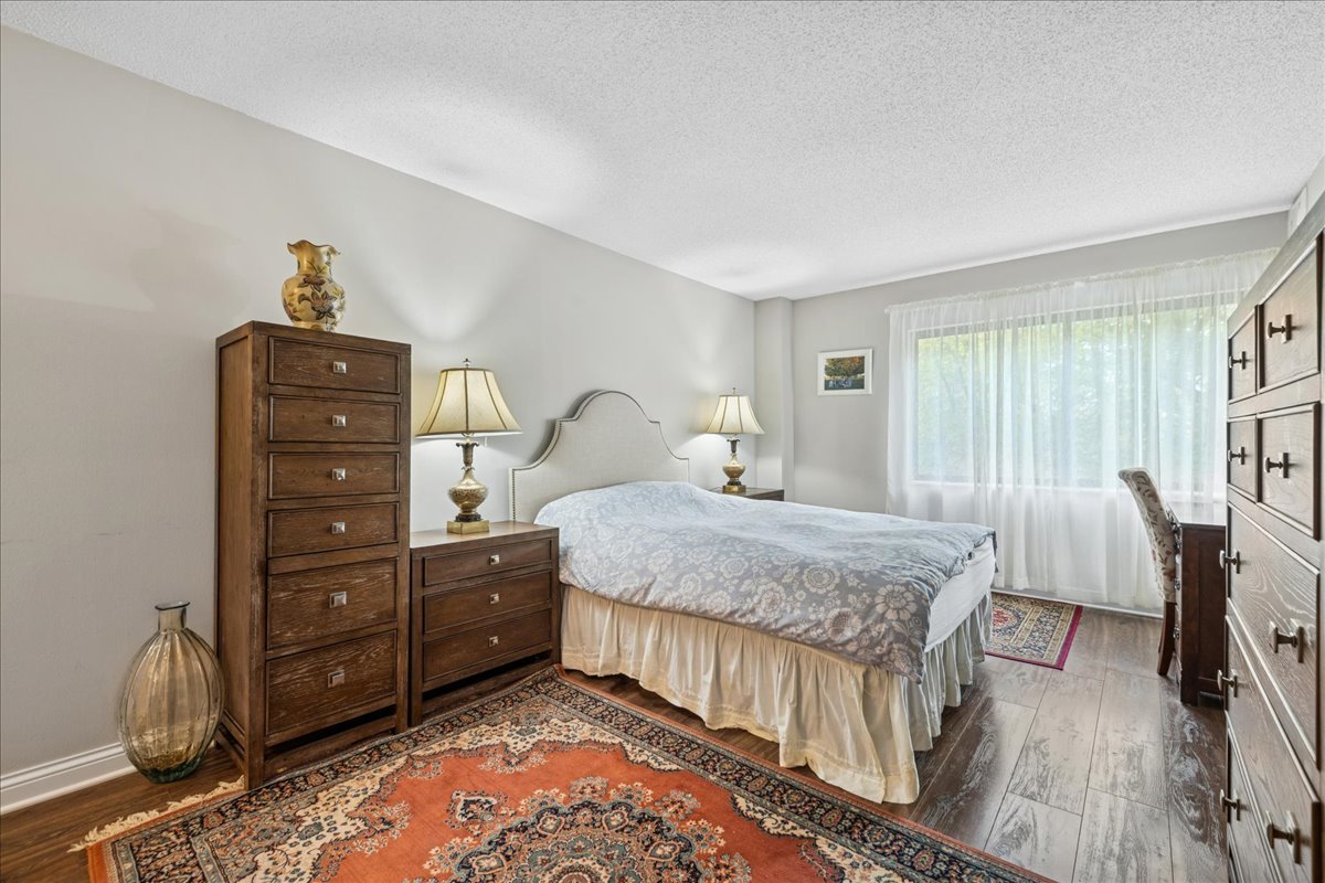 1800 Huntington Boulevard, Unit 212 Hoffman Estates, IL 60169 - Photo 10 of 15 a bedroom with a bed and a dresser