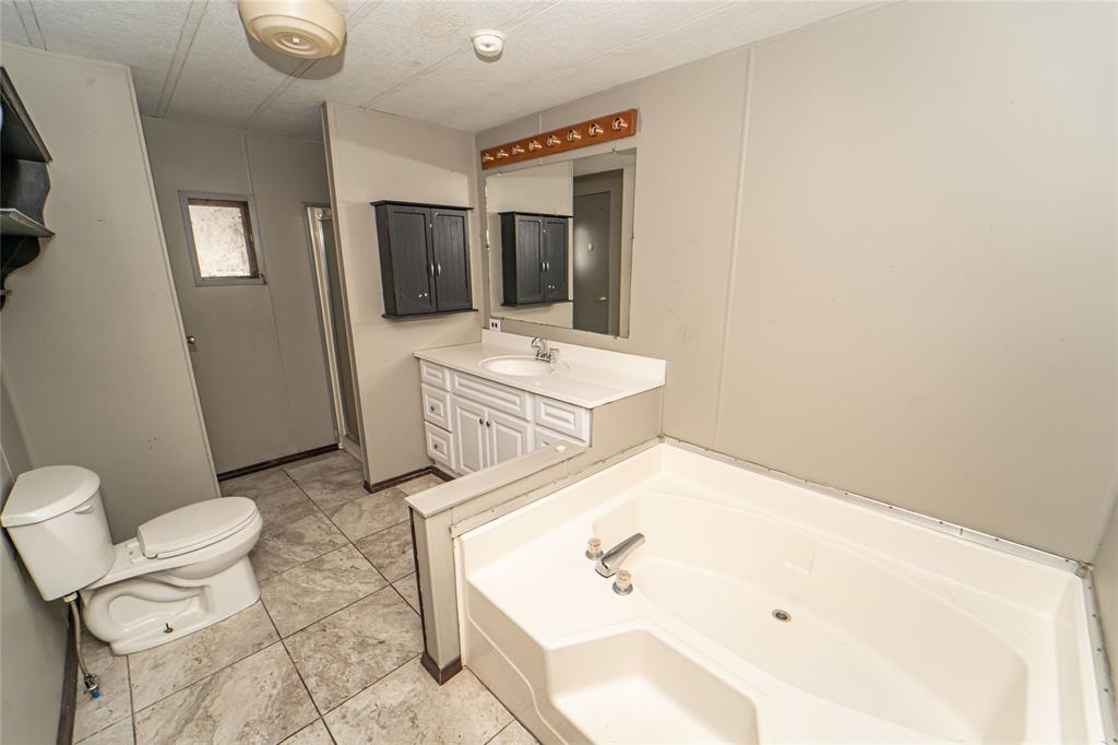 122 County Road 306 Breckenridge, TX 76424 - Photo 15 of 40 a bathroom with a sink toilet and shower
