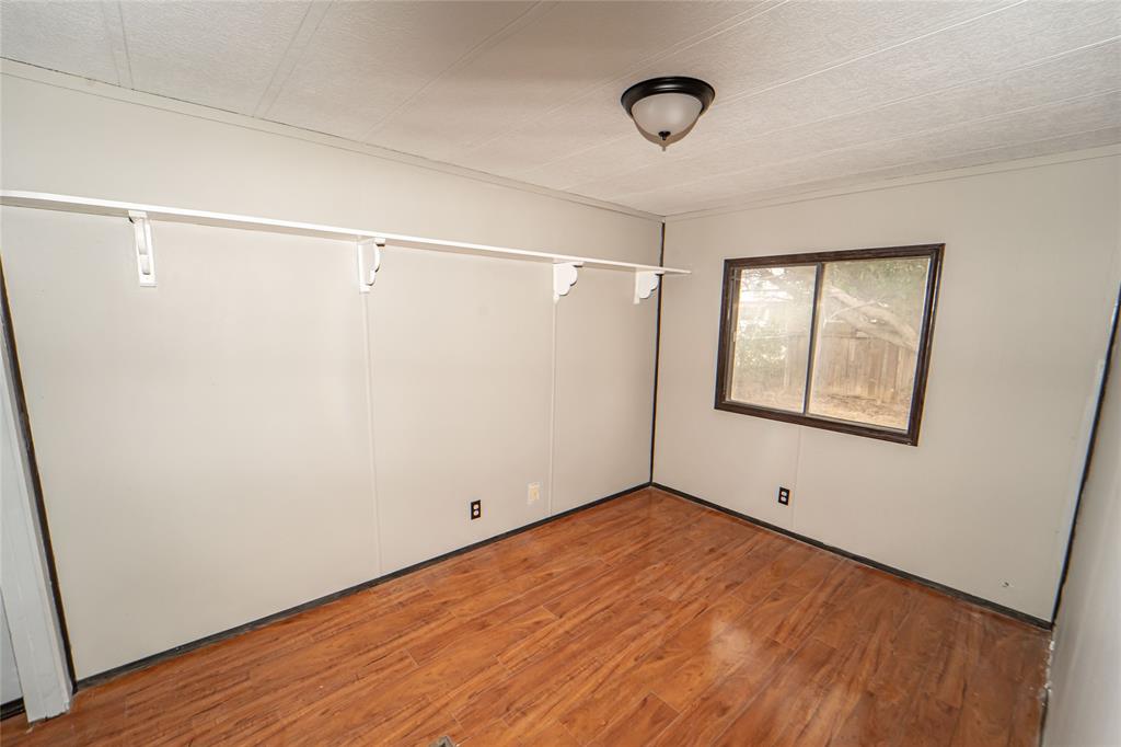 122 County Road 306 Breckenridge, TX 76424 - Photo 21 of 40 a view of an empty room with wooden floor and a window