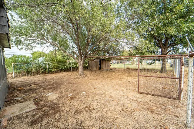 a view of a house with yard and tree