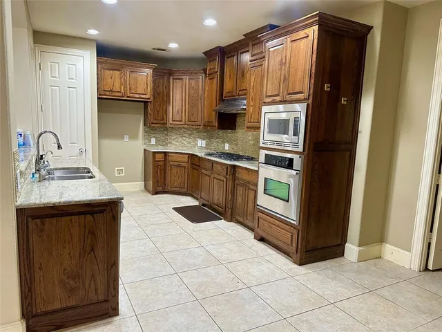 a kitchen with stainless steel appliances granite countertop a refrigerator and a sink
