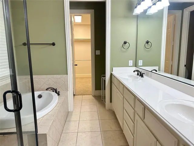 a bathroom with a tub sink and mirror