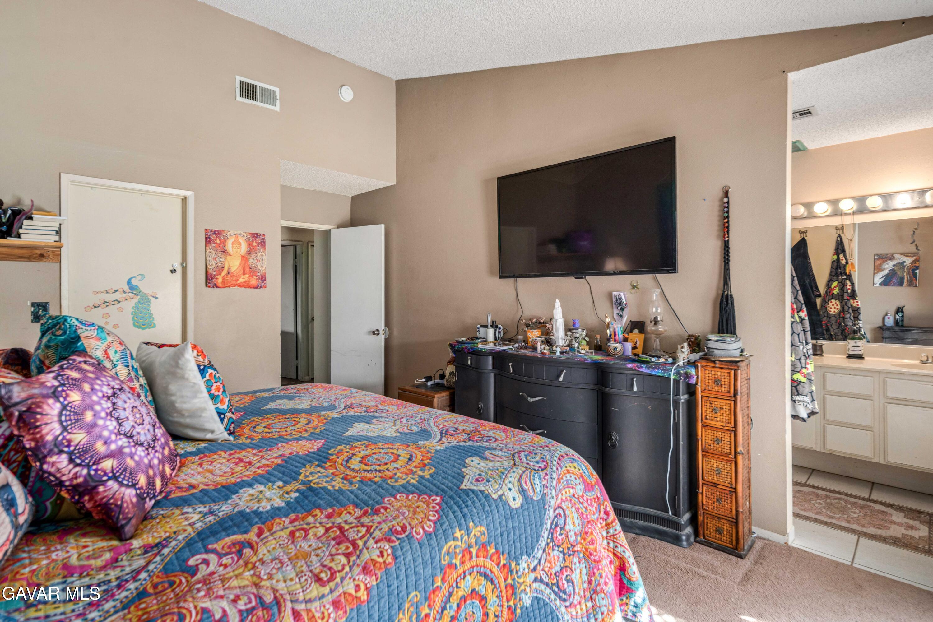 3112 Myrtle Street Rosamond, CA 93560 - Photo 14 of 49 a bedroom with a bed and a flat screen tv