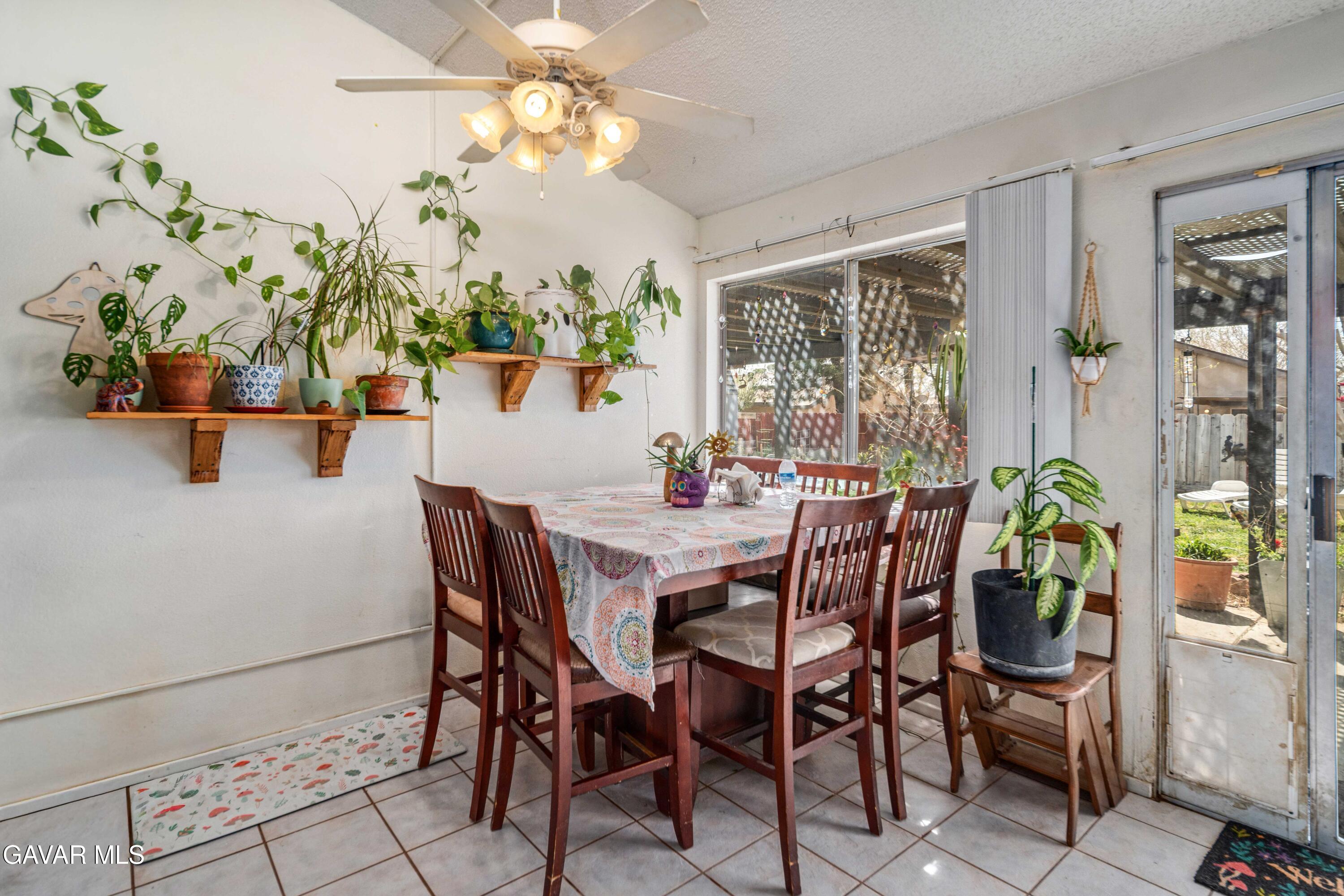 3112 Myrtle Street Rosamond, CA 93560 - Photo 10 of 49 a dining room with furniture potted plants and wooden floor