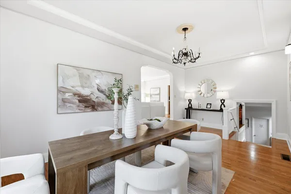a kitchen with stainless steel appliances granite countertop a refrigerator a sink dishwasher a stove a dining table and chairs with wooden floor