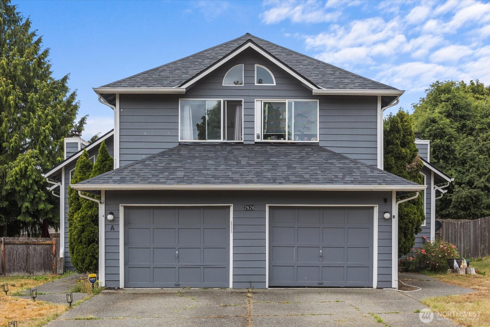 2826 Northeast 8th Street Renton, WA 98056 - Photo 2 of 20 a front view of a house with a yard and garage