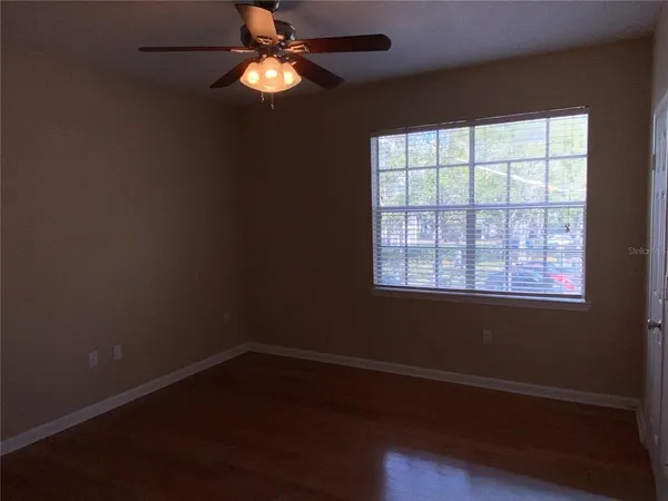 en empty room with wooden floor and windows