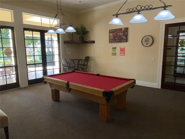 a room with pool table and windows