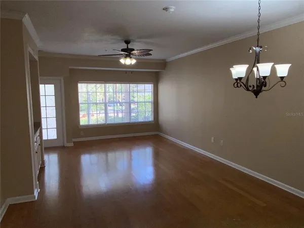 a view of a room with wooden floor and chandelier