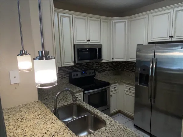 a kitchen with a sink stove and refrigerator