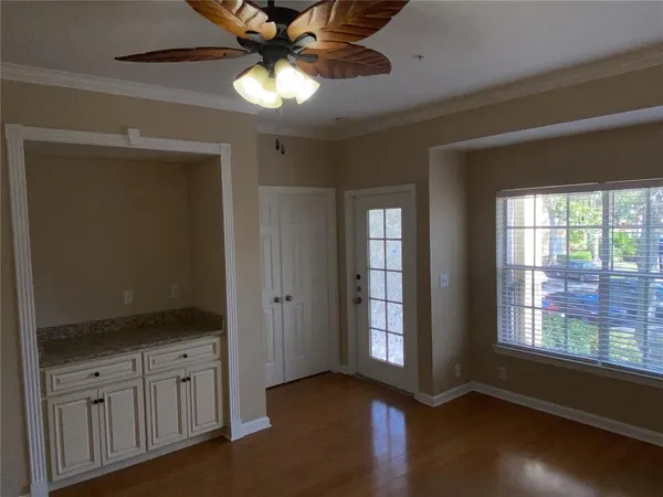 a view of an empty room with window and wooden floor