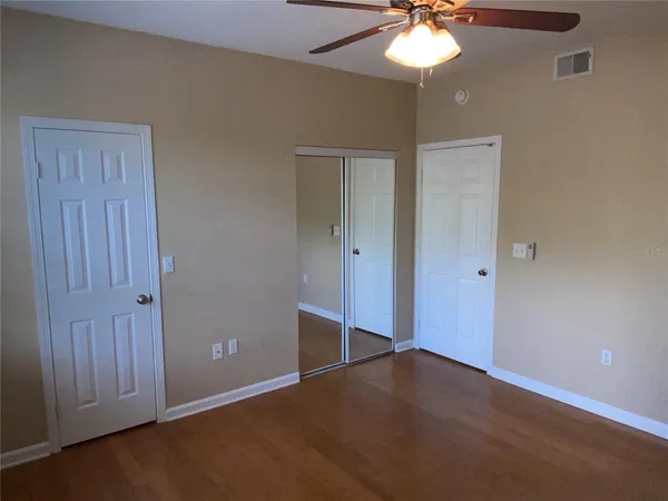a view of an empty room with a chandelier fan