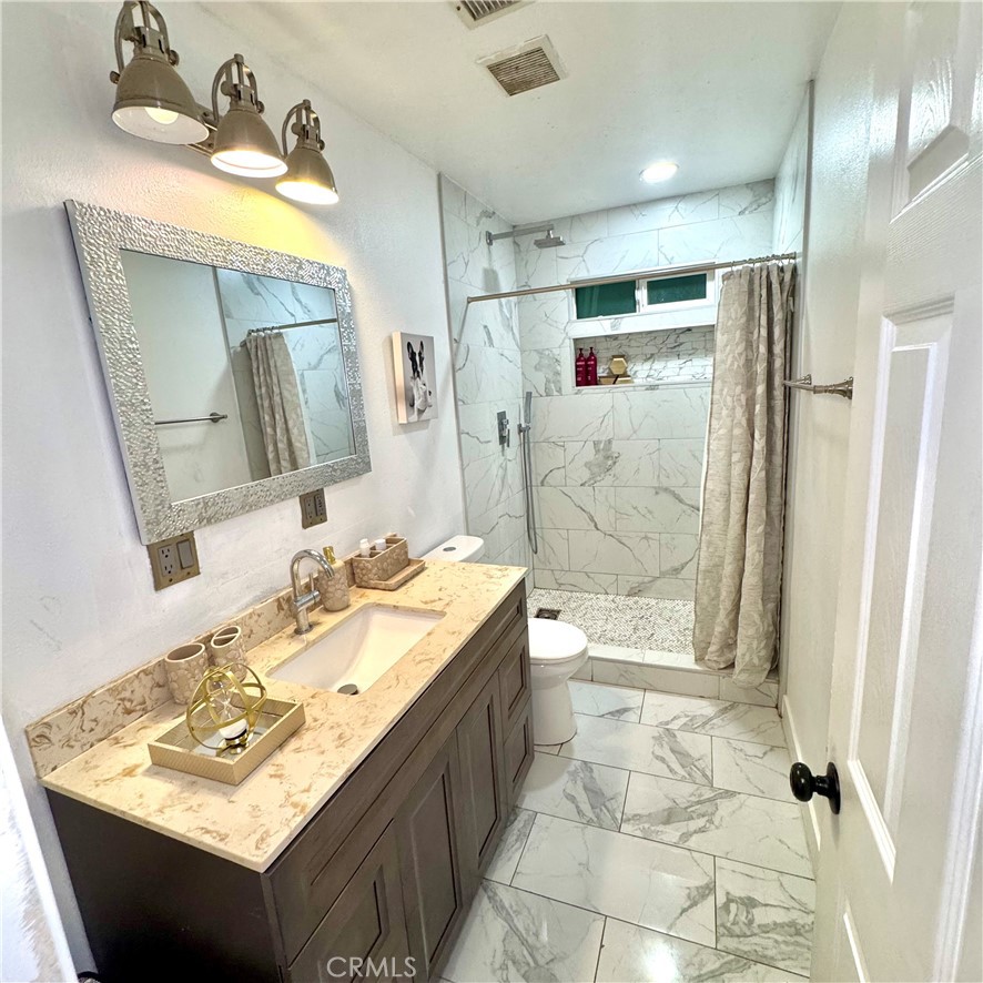 5642 Babb Avenue Riverside, CA 92503 - Photo 14 of 41 a bathroom with a sink vanity granite tub shower and a mirror