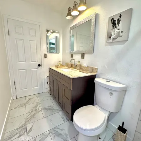 a bathroom with a toilet sink vanity and mirror