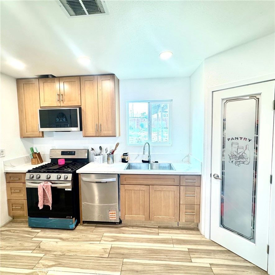 5642 Babb Avenue Riverside, CA 92503 - Photo 4 of 41 a kitchen with a stove a sink and a refrigerator