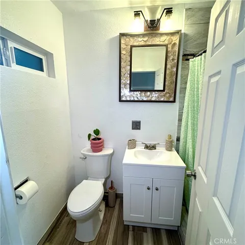 a bathroom with a toilet sink vanity and mirror