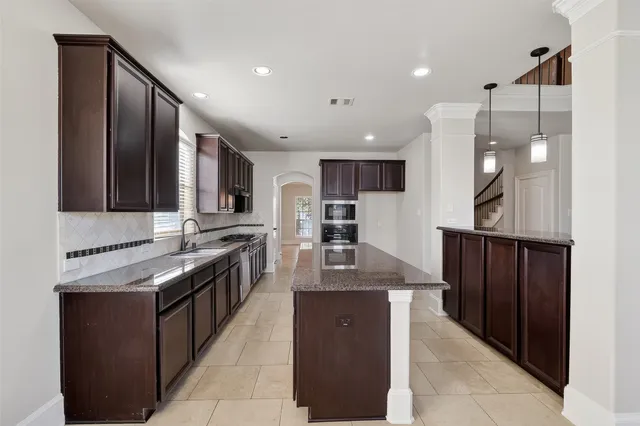 a kitchen with stainless steel appliances granite countertop wooden cabinets a sink and dishwasher