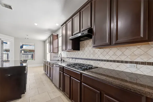 a kitchen with stainless steel appliances granite countertop a sink stove and cabinets