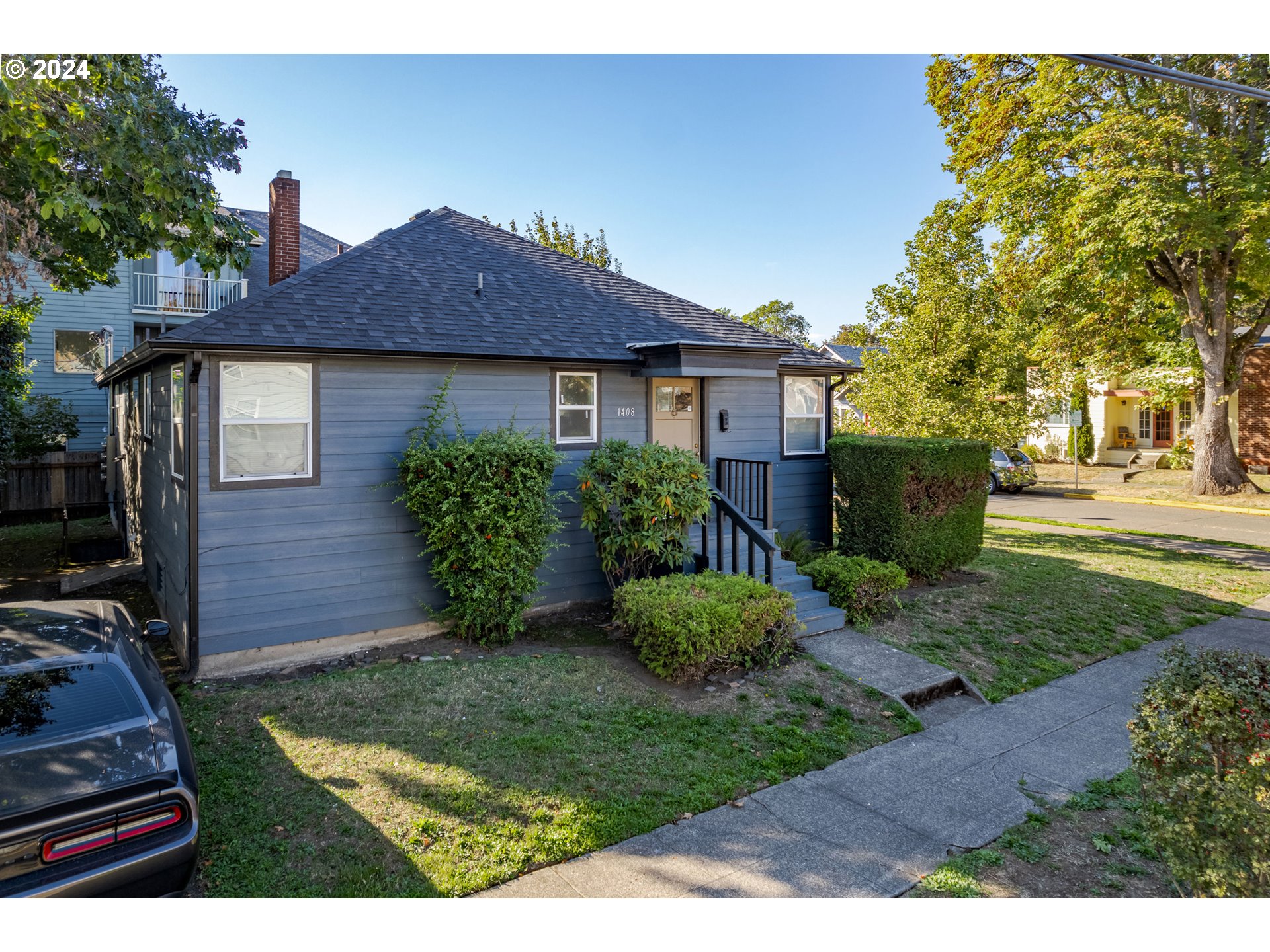 1408 Ferry Street Eugene, OR 97401 - Photo 3 of 20 a view of a house with brick walls and a yard with plants