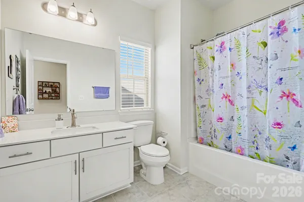 a bathroom with a sink a toilet and a shower curtain
