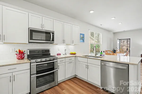 a kitchen with stainless steel appliances a stove microwave and cabinets