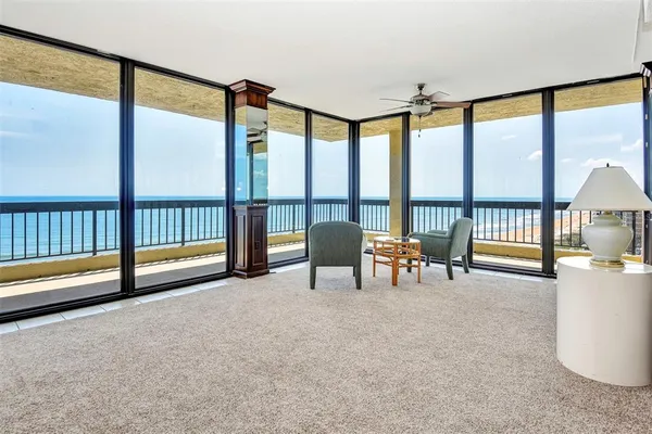 a living room with furniture and large windows
