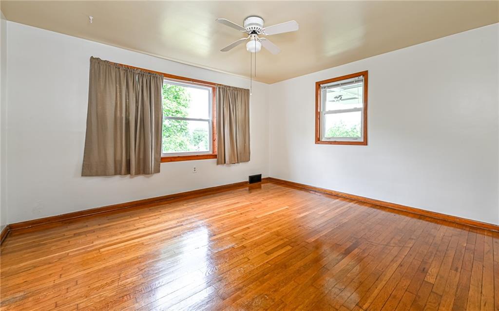 2760 Ridge Rd Extension Baden, PA 15005 - Photo 6 of 23 an empty room with wooden floor ceiling fan and windows
