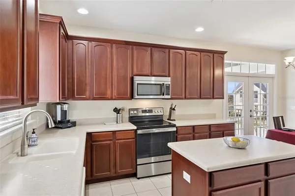 a kitchen with stainless steel appliances wooden cabinets a stove a sink and a microwave