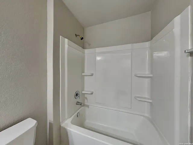 a white bath tub sitting next to a white toilet