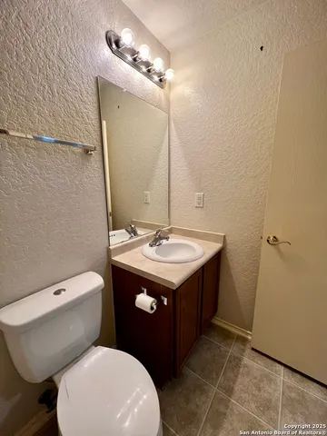 a bathroom with a granite countertop toilet sink and mirror