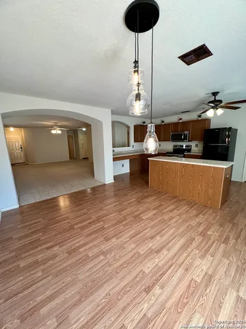 a kitchen with stainless steel appliances granite countertop a sink dishwasher and a stove with wooden floor