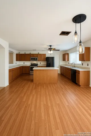 a kitchen with stainless steel appliances wooden floor and large windows