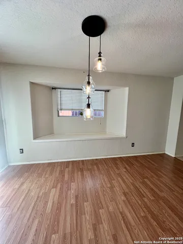 a view of a room with wooden floor and a chandelier