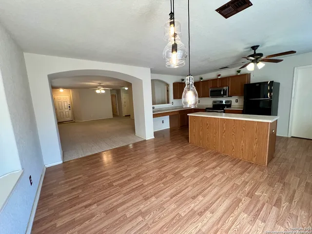 a view of a living room a kitchen and a wooden floor
